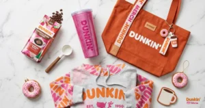 Flatlay of Dunkin seasonal merchandise including pink glitter tumbler tote bag and hoodie